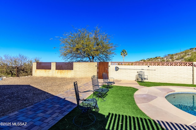 view of yard featuring a fenced in pool and a patio