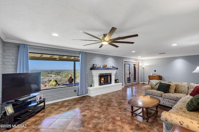 living room featuring crown molding, ceiling fan, and a fireplace