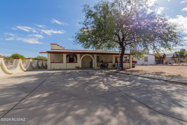 ranch-style house featuring fence