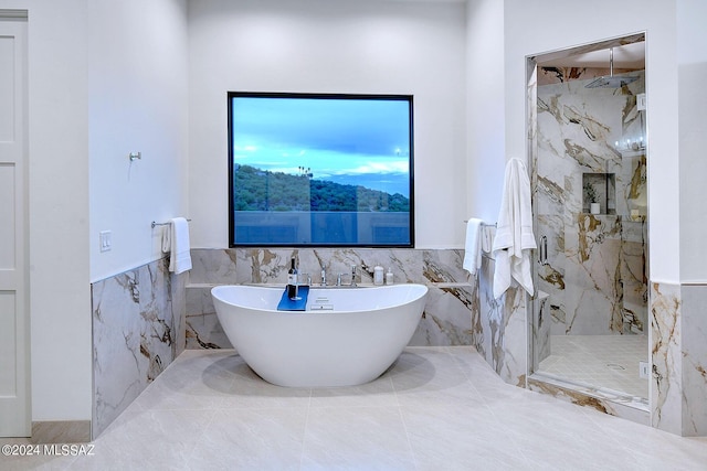 bathroom featuring tile walls and shower with separate bathtub