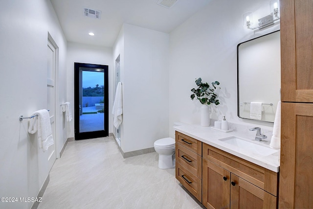 bathroom with toilet, tile patterned flooring, and vanity