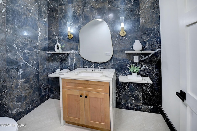 bathroom with toilet, vanity, and tile walls