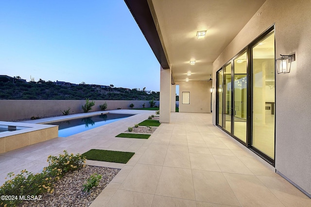 pool at dusk with a patio