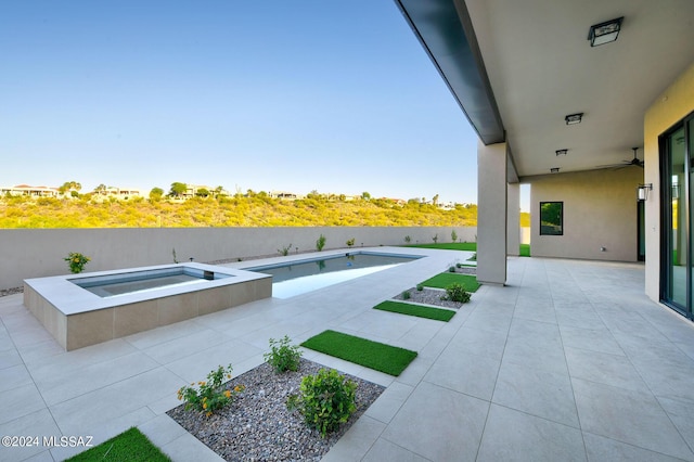 view of patio with a swimming pool with hot tub