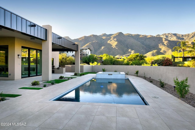 view of swimming pool with a mountain view and a patio