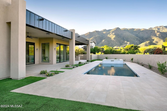 view of pool with a mountain view, ceiling fan, and a patio