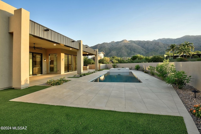 view of pool with a mountain view, ceiling fan, and a patio