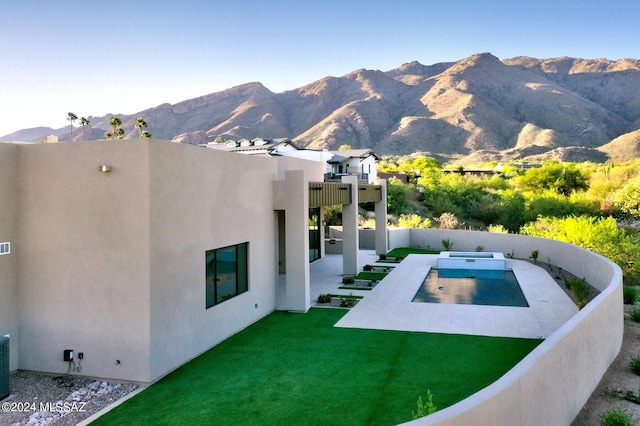 exterior space featuring a mountain view, a patio area, and a yard