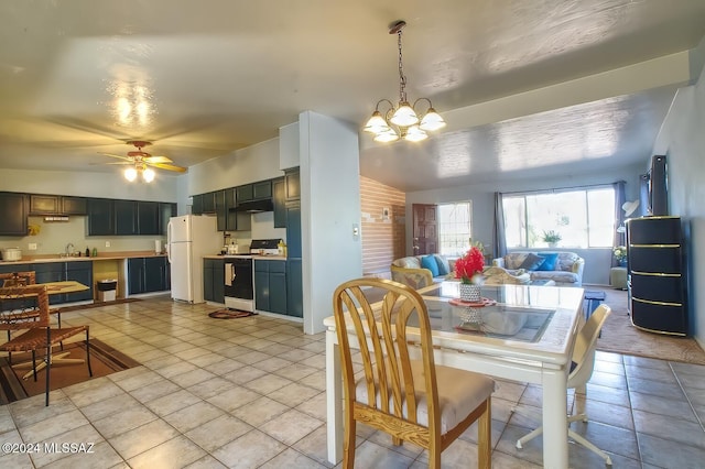 dining space featuring sink, ceiling fan with notable chandelier, and light tile patterned floors