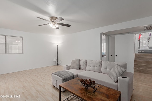 living room with light hardwood / wood-style flooring and ceiling fan