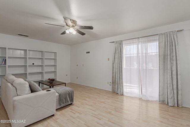 living room with ceiling fan and light hardwood / wood-style flooring