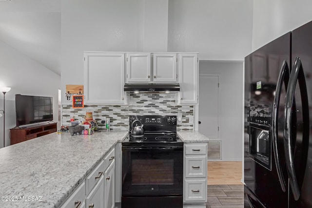 kitchen featuring black appliances, tasteful backsplash, white cabinets, and light stone counters