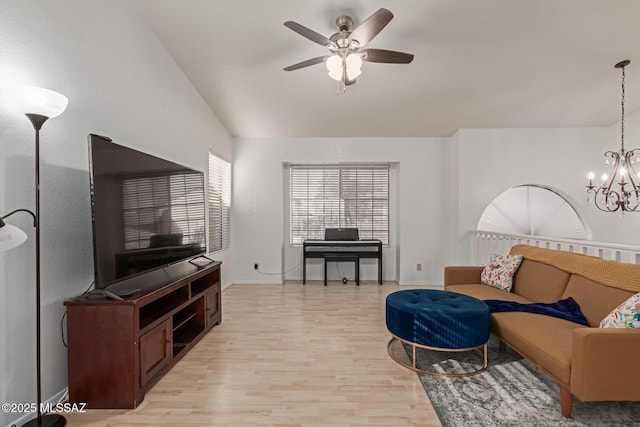 living room featuring light hardwood / wood-style floors, ceiling fan with notable chandelier, and lofted ceiling