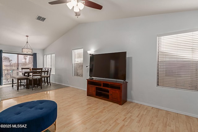 living room featuring ceiling fan, light hardwood / wood-style floors, and lofted ceiling