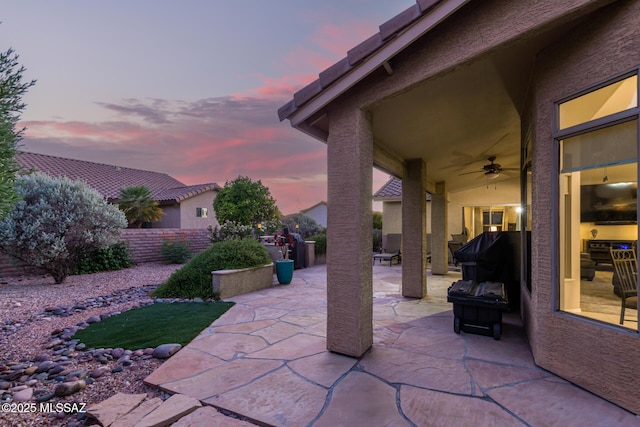 patio terrace at dusk featuring ceiling fan