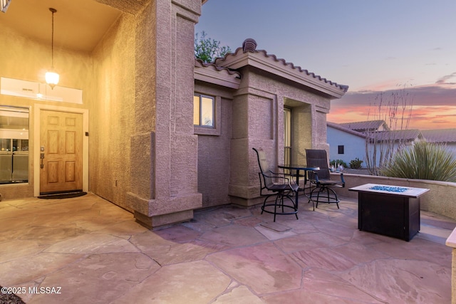 patio terrace at dusk featuring an outdoor fire pit