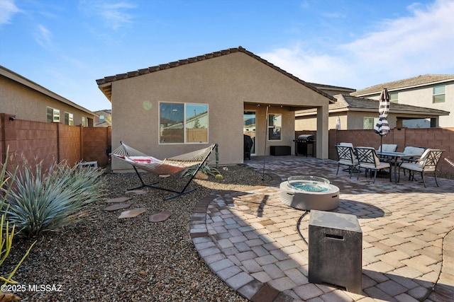 back of house featuring a patio area and an outdoor fire pit