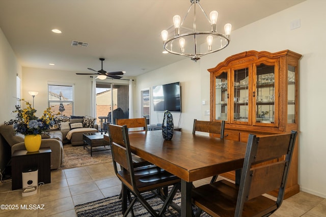 tiled dining area with ceiling fan with notable chandelier