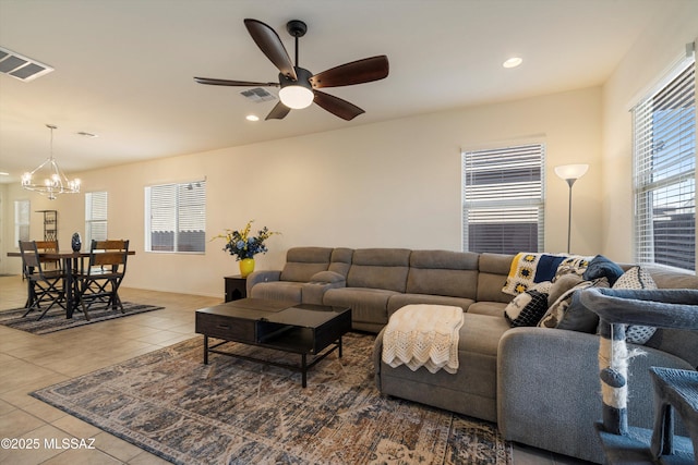 living room featuring ceiling fan with notable chandelier and tile patterned floors