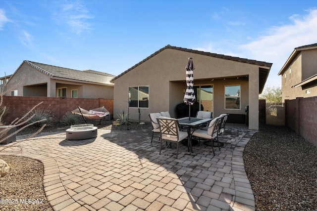 back of house featuring a fire pit and a patio area