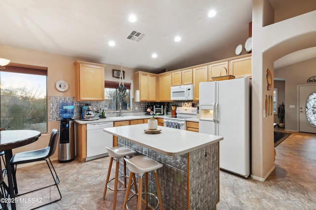 kitchen with white appliances, visible vents, light countertops, light brown cabinets, and backsplash