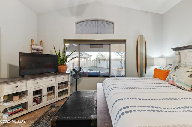 bedroom with lofted ceiling and access to exterior