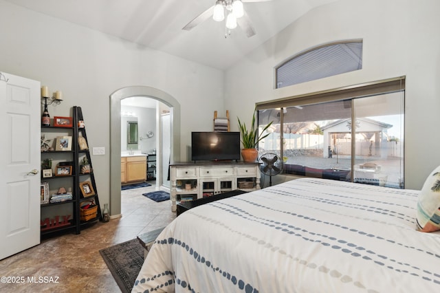 bedroom with arched walkways, a sink, access to exterior, vaulted ceiling, and ensuite bath