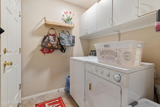 clothes washing area featuring cabinet space, separate washer and dryer, and baseboards