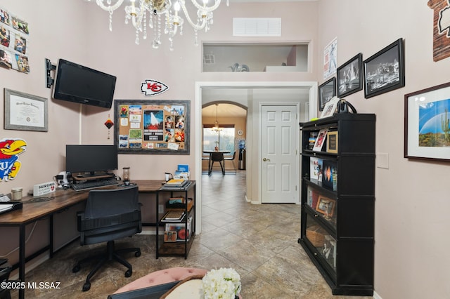 office featuring a chandelier, arched walkways, and visible vents