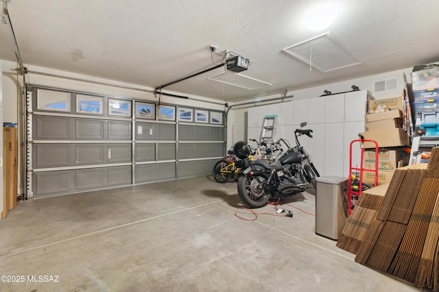 garage with a garage door opener and visible vents