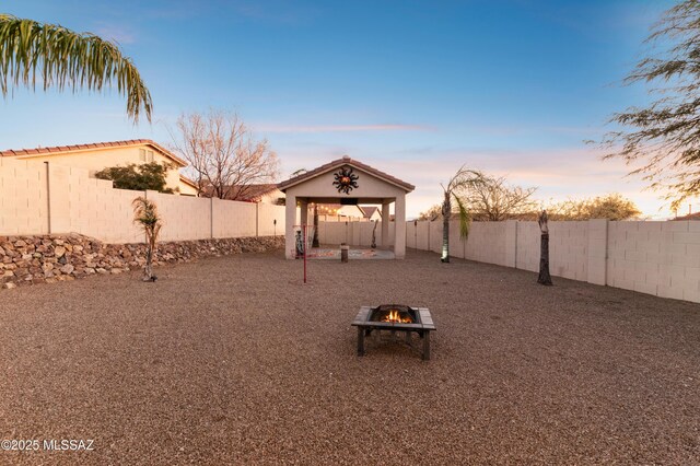 back of house with stucco siding, a patio area, a fire pit, and a fenced backyard