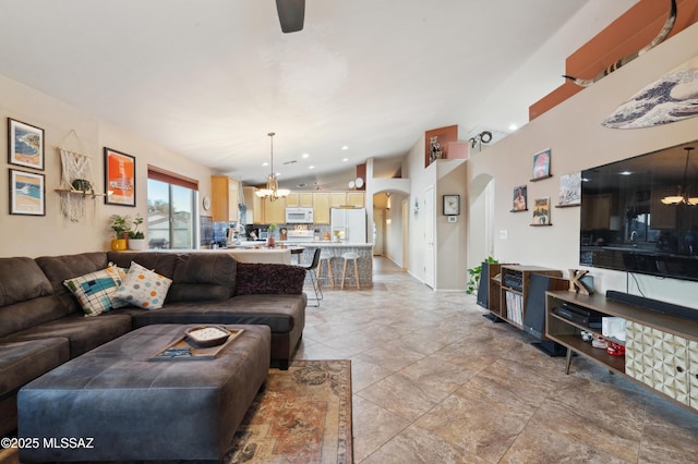 living room featuring arched walkways and an inviting chandelier