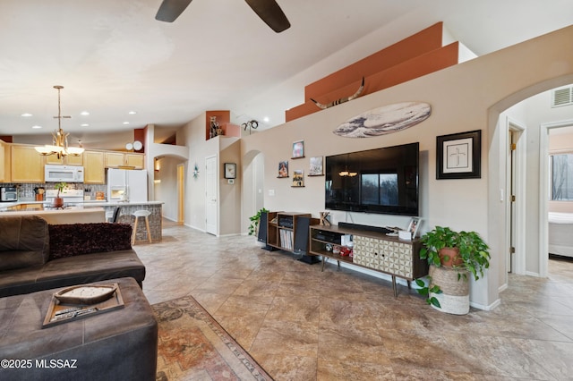 living area featuring arched walkways, baseboards, recessed lighting, and ceiling fan with notable chandelier
