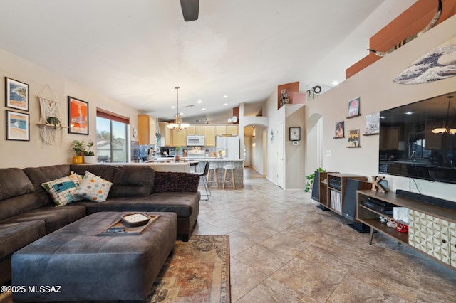 living area with arched walkways, vaulted ceiling, recessed lighting, and an inviting chandelier