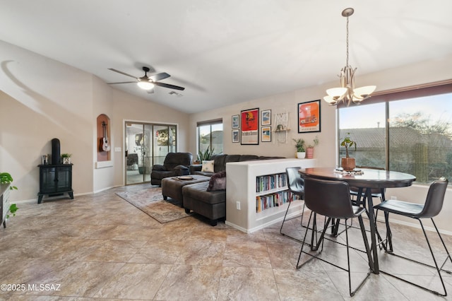 dining space with lofted ceiling, baseboards, and ceiling fan with notable chandelier