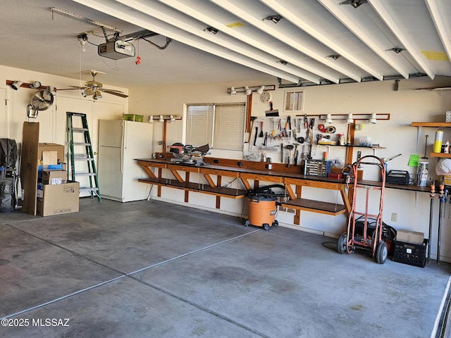 garage featuring a workshop area, white fridge, and a garage door opener