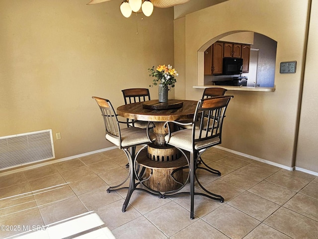 tiled dining area featuring ceiling fan