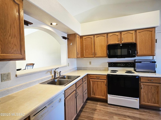 kitchen with dishwasher, lofted ceiling, dark wood-type flooring, sink, and electric range