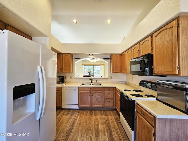 kitchen with sink, white appliances, and dark wood-type flooring