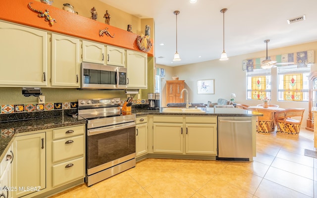 kitchen featuring a sink, stainless steel appliances, visible vents, decorative light fixtures, and a peninsula