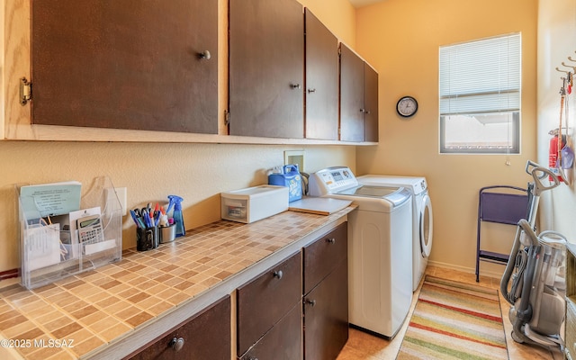 washroom featuring cabinet space and independent washer and dryer