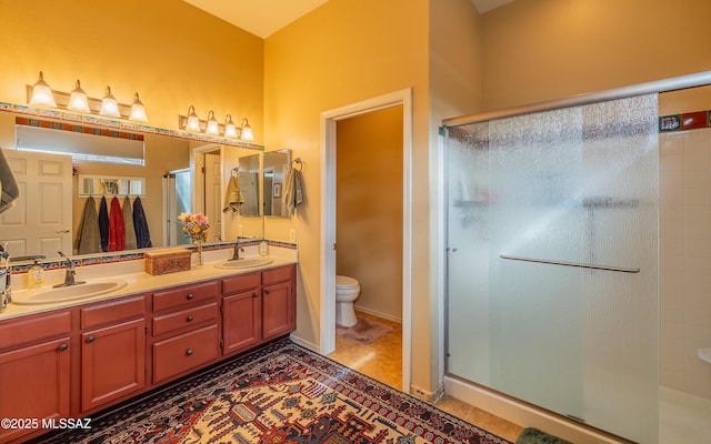 bathroom featuring tile patterned flooring, vanity, toilet, and walk in shower