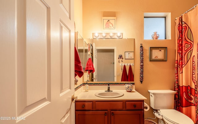 bathroom featuring toilet, a textured wall, and vanity