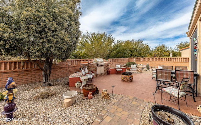 view of patio featuring an outdoor kitchen, a grill, and a fire pit