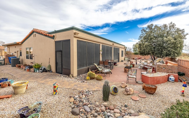 rear view of property with fence, cooling unit, a patio, and stucco siding