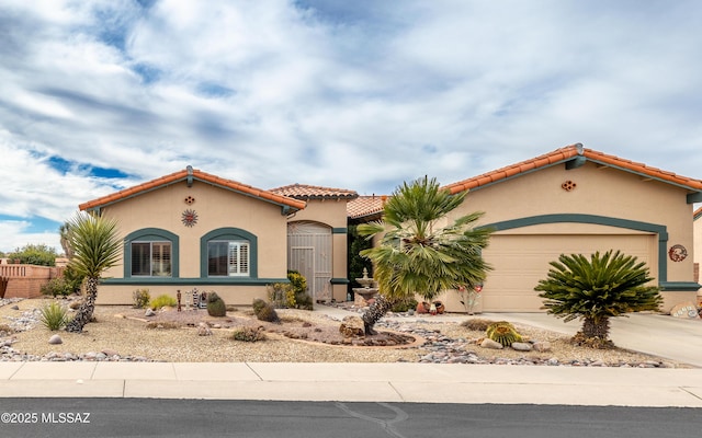 mediterranean / spanish-style house featuring stucco siding, concrete driveway, a tiled roof, and an attached garage