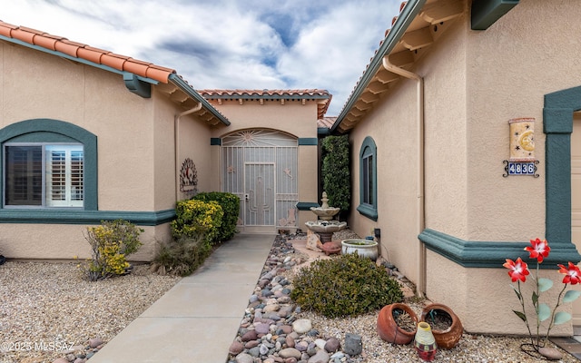 property entrance featuring stucco siding and a tiled roof