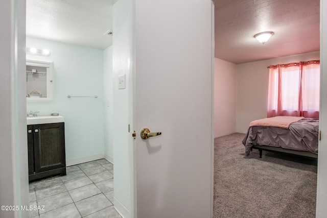 carpeted bedroom with a textured ceiling and ensuite bathroom