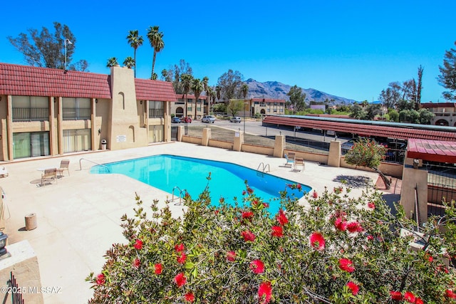 view of swimming pool with a mountain view and a patio