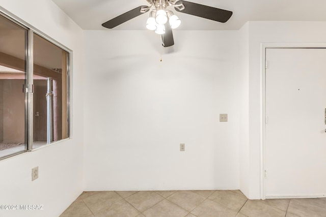 tiled spare room featuring ceiling fan